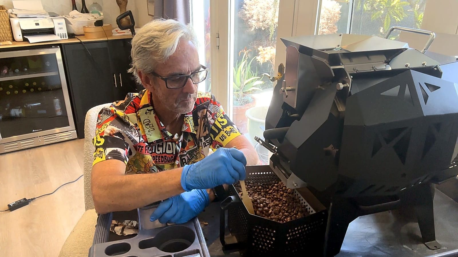Robert McCray stirring freshly roasted coffee in the cooling tray of a small roaster at home in Westminster, California.