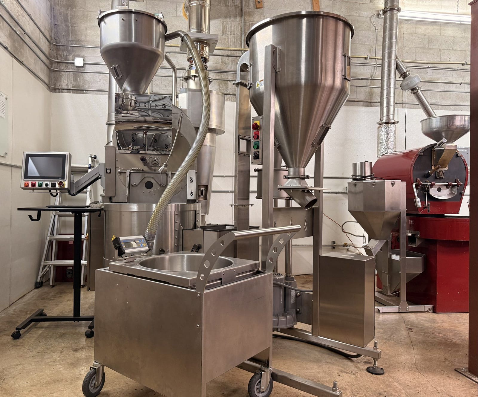 Coffee roasting machines and loading hoppers at the Múcaro Coffees roastery.